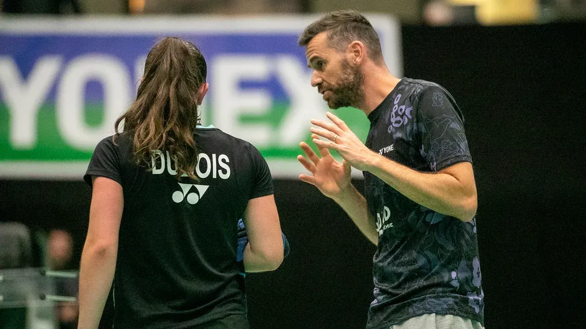 Deux joueurs en séance de coaching devant un panneau Yonex à l'Arena