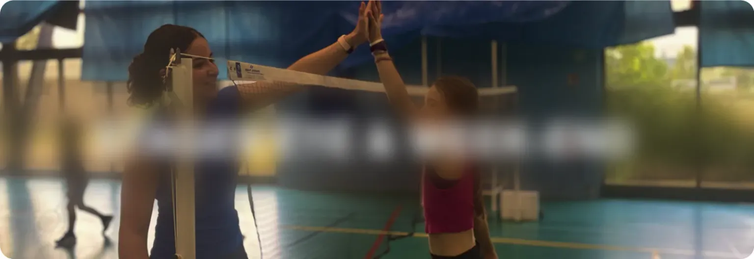 Deux jeunes joueuses se félicitant par-dessus le filet pendant un stage
