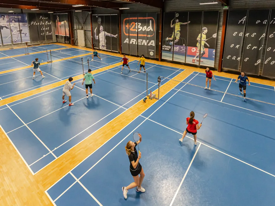 Les terrains de badminton de la +2Bad Arena vus depuis le fond de salle