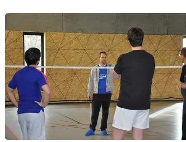Coach en pleine séance collective avec un groupe de joueurs à la +2Bad Arena de Rennes