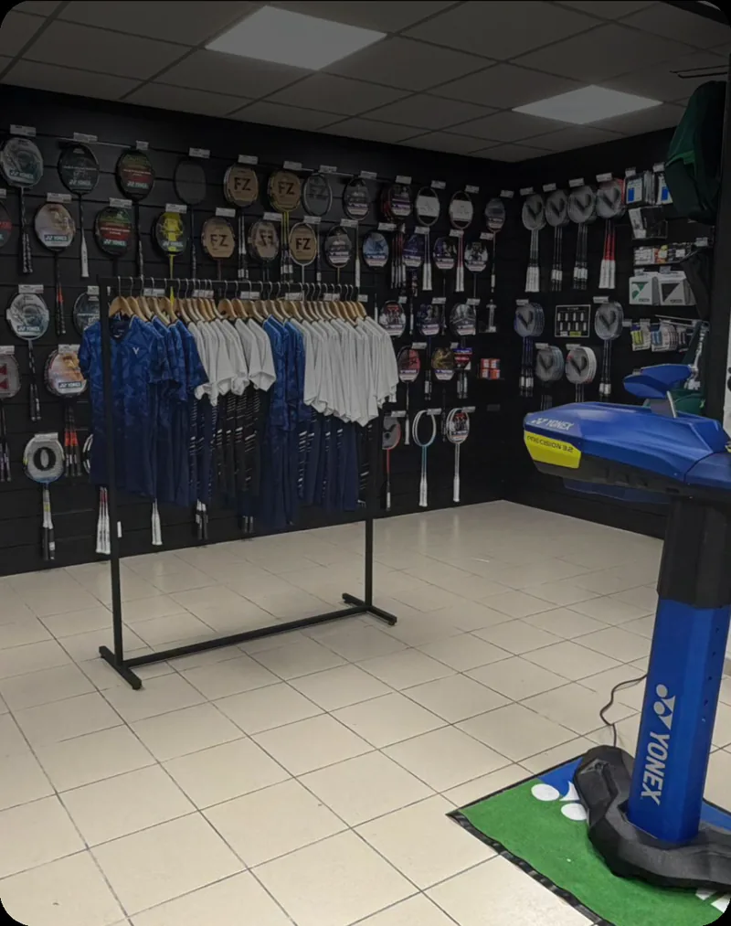 Intérieur du magasin +2Bad Lille, portants de textile et mur de raquettes