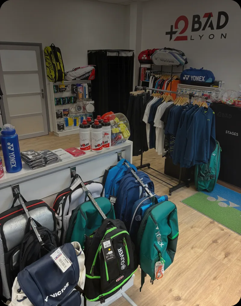 Magasin +2Bad Lyon, enseigne au mur et rayon sacs de badminton