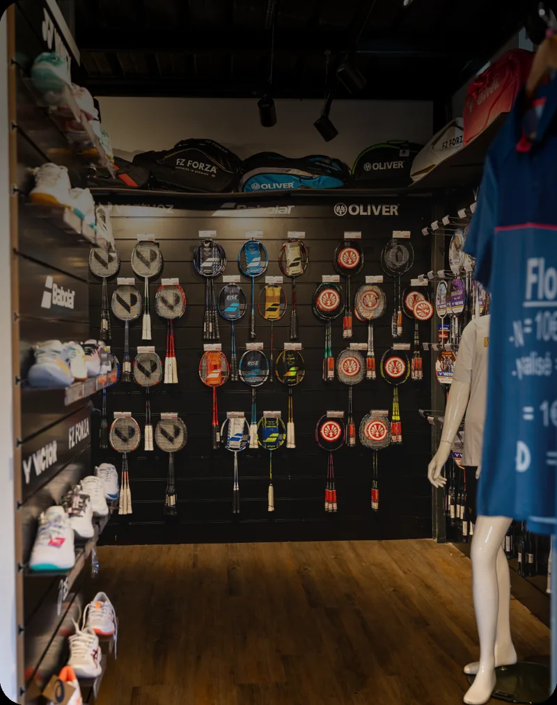 Intérieur du magasin +2Bad Rennes, mur de raquettes et rayon chaussures